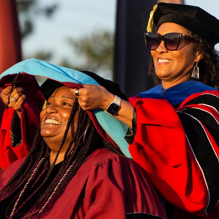 School of Education graduate student receiving their diploma in commencement.